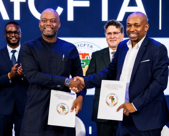 Wamkele Mene (left), Secretary-General of AfCFTA, exchange signed ADTC agreement with Philip Gamey, Executive Chair or Quest Ghana (right)